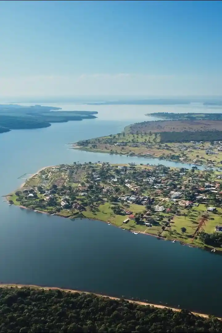 Vista aérea da Represa Jurumirim, com casas na margem e a água dos dois lados.